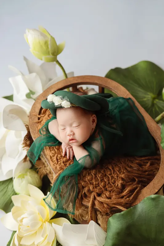 Neugeborenes mit Kuscheltieren und Blumendeko