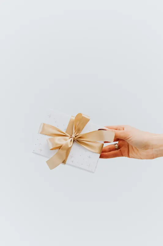Hand übergibt ein kleines Geschenk