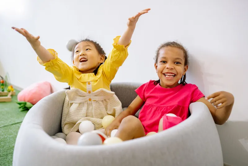 Zwei Kinder jubeln im Bällebad