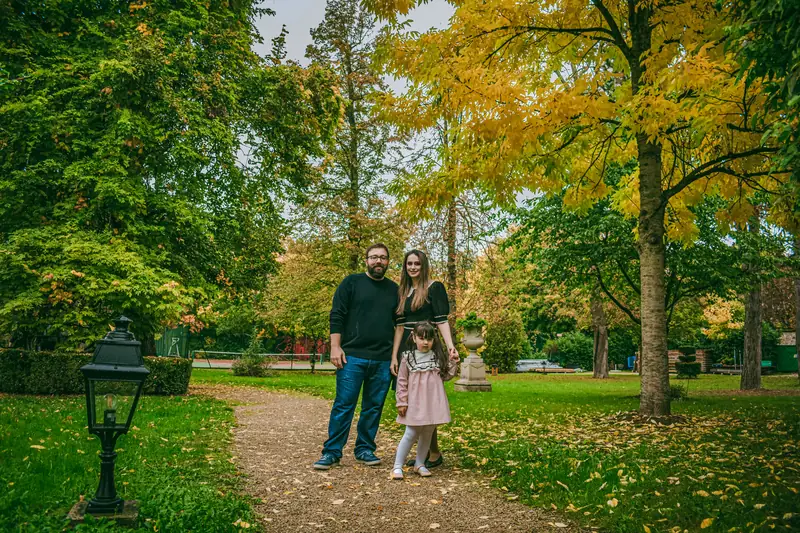 Paar mit Kind spaziert auf herbstlichem Weg