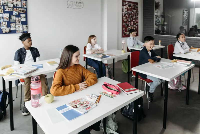 Kinder sitzen an Schultischen in einem modernen Klassenzimmer